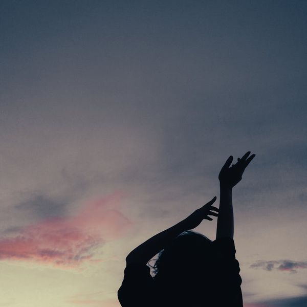 Person meditating peacefully outdoors with a calm expression.